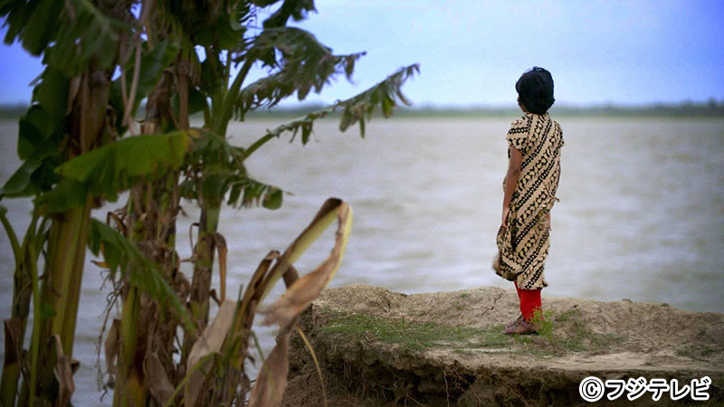 A young girl looks at the ground on Ghoramara Island, which is gradually sinking due to rise in sea levels.