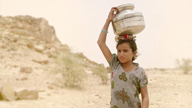 A young girl walks 10 kilometers through a desert, in the blazing heat for water